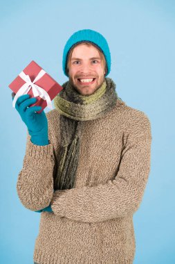 Kışın güzelliğini keşfedin. Adam yılbaşı hediyesini tutuyor. Hediye kutusuyla birlikte kışlık elbiseli mutlu bir adam. Havada kış var.