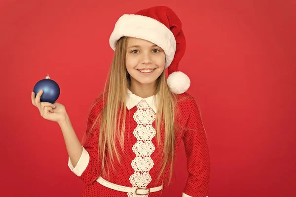 Hoe eerder u winkelt voor decoraties, hoe goedkoper ze zullen zijn. Creëer unieke decoraties. Kerstbal decor. Kerstversiering ideeën voor kinderen kamer. Kind rood kostuum houden kerst ornament — Stockfoto