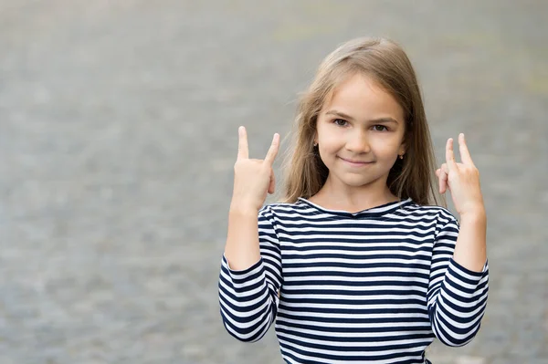 Feliz niño pequeño mostrar cuernos señales de mano con estilo de moda casual al aire libre, fresco, espacio de copia — Foto de Stock