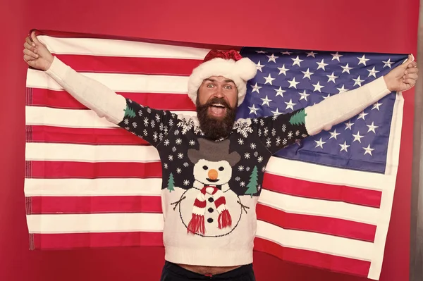 Christmas holiday. Guy celebrate christmas. Cheerful hipster. Love your country. Christmas in United States of America. Greetings to all my compatriots. American man hold USA flag. National spirit