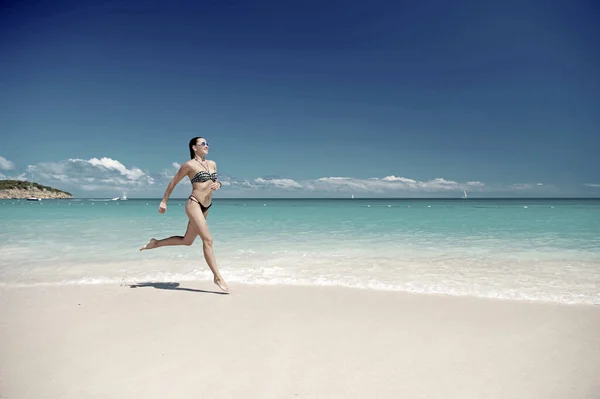 Giovane donna che corre sulla spiaggia tropicale — Foto Stock