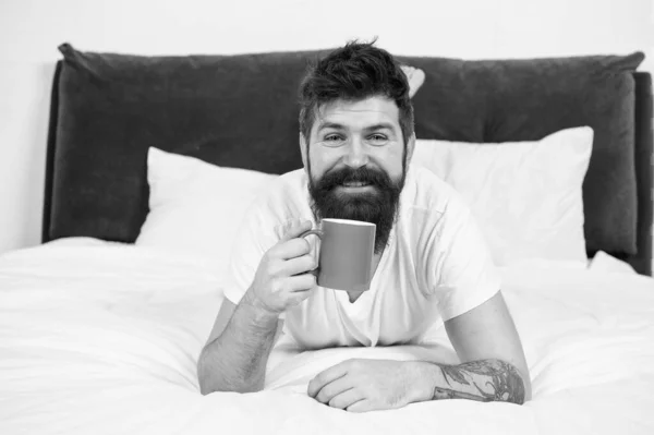 Uyan ve kahveyi kokla. Mutlu hipster sabahları kahve içer. Sakallı adam yatakta kahveyi sever. Sıcak içecek. Kahvaltılık çay. Rahatlatıcı ruh hali. Günaydın kahveyle başlıyor. — Stok fotoğraf