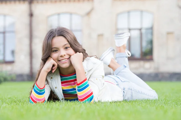 Niño niña feliz en el estilo de moda casual relajarse tumbado en la hierba verde en el día de verano, el descanso —  Fotos de Stock