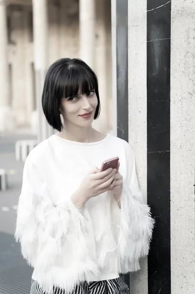 Mulher com cabelo morena segurar telefone celular. Mulher com lábios vermelhos usar smartphone em Paris, França. Menina de beleza com olhar sexy. Modelo de moda com dispositivo móvel. Nova tecnologia para a vida moderna — Fotografia de Stock