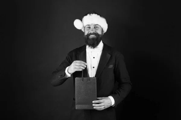 サンタクロースはみんなの願いを満たすためにここにいます。サンタの顔を持つ幸せなビジネスマン。髭の男は買い物袋を持っている。サンタからクリスマスプレゼント。サンタ・パーティーだ。新年の贈り物、コピースペース — ストック写真