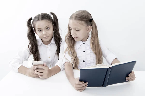 Concept d'innovation et d'archaïsme. Les enfants lisent le livre papier et l'appareil mobile électronique en utilisant l'innovation et l'archaïsme — Photo