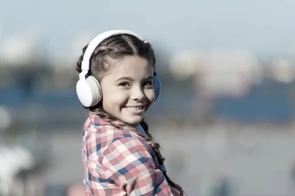 La musica le dà un grande piacere. Bambino carino con auricolare wireless. Bambino piccolo con le cuffie stereo. Bambina che ascolta musica. Adorabile bambino che utilizza la tecnologia per il tempo libero o l'istruzione — Foto Stock