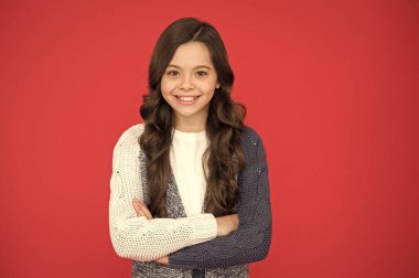 Doğal bukleler. Çocuk şirin, sevimli, kıvırcık saçlı. Uzun saçlı, kendine güvenen bir çocuk. Kıvırcık saçlı kız kendine güveniyor. Çocuk psikolojisi ve gelişimi. Kendine güvenen duruş. Sevimli gülümseme