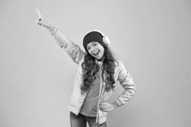 Küçük çocuk müzik kulaklığı. çocuk uzun kıvırcık saçlı. Kış mevsiminde saç bakımı. Soğuk hava için sıcak kıyafetler. Tatil zamanı. Mutlu küçük kız pembe bir hayat yaşıyor. En sevdiği renk pembe.