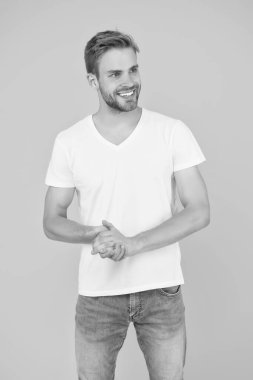 Karizma konsepti. Yüz bakımı. Güzel insanlar. Yakışıklı genç adam. Tıraşsız yakışıklı bir adam. Tüylü hippi beyaz tişört giyer. Yakışıklı adam poz veriyor. Karizmatik maço. Yakışıklı seksi adam.