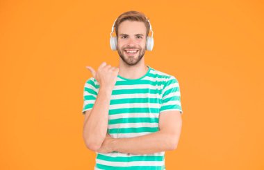 Neşeli bir ruh hali. Motivasyon için müzik. Favori parça listesi ile rahat egzersiz. Spor için kablosuz kulaklıklar. Modern kulaklık konsepti. Adam yakışıklı sporcu müzik kulaklık gadget dinleme