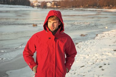 Kutup kaşifi. Güneşli kış günü. Kış erkek giyim. Kış kıyafeti. Rahat bir kıyafet. Erkek ceketi. Sıcak ceketli, karlı bir arka plan. Rüzgara dayanıklı kıyafetler. Kışın balık. Güvenlik önlemleri