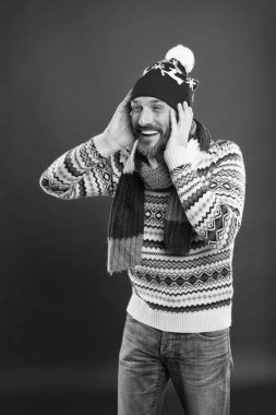 Moda ve tarz. Kış trendleri. Şapka atkısı ve kazak. Kış örgüsü. Örgü aksesuarlar. Olgun erkek kırmızı arka plan. Kışın sakallı adam. Beyaz adam kalın kıyafetler giyiyor.