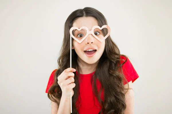 Lindo chico con accesorios de fiesta de lujo. Proveedor de decoraciones de fiesta. Tienda de fiestas. Concepto de San Valentín. Objetos de gafas de niño feliz. Muchacha divertida sosteniendo gafas cabina de fotos apoyos en palo — Foto de Stock