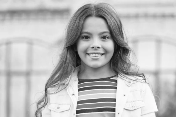 Lindo por dentro e por fora. Criança feliz sorrir ao ar livre. Beleza olhar de menina. Criança pequena em desgaste casual. Tendência moda. Estilo moderno. Cuidados infantis e infância. Dia internacional das crianças — Fotografia de Stock