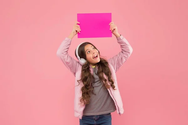 Was ist das? Online-Bildungsankündigung. Werbetechnik. Kindheitsentwicklung. Überraschte Kinder mit Kopfhörern hören Musik. zurück zur Schule. Kind hält leeres Papier für Kopierraum — Stockfoto