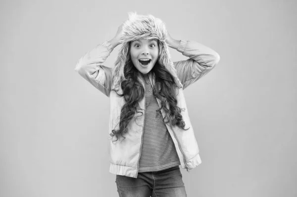 Én nem hiszek benne. szőrme fülvédő sapka tartozék. Kislány téli kalap. meleg ruhák a hideg évszakra. Kölyök divat. A lány úgy néz ki, mint egy hipster. boldog gyerek rózsaszín háttér. Őszi stílus. Gyermekkori aktivitás — Stock Fotó