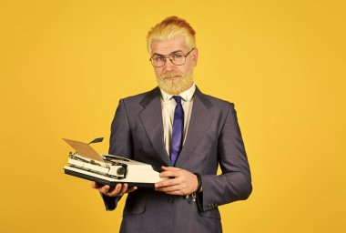 İkinci el eşya mağazası. Satıcı vintage objeler. Vintage değerler uzmanıyım. Klasik daktilo. İş adamı geçmişe dönük teknoloji kullanır. Olgun bir adam sakalını sarıya boyadı. Yazar eski alışkanlıklara yapışır