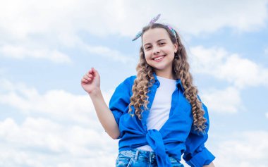 Mutlu çocuk gökyüzü arka planında kareli gömlek giyiyor, klasik tarzda.