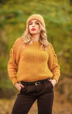 Tarz tamamen denge ile ilgilidir. Kadınlar kalın süveter giyer arka planda odaklanmazlar. Sonbahar parkında yürü. Süslü kız örgü süveter giyiyor. Yünlü süveter içinde kendini rahat hisseden muhteşem bir bayan. Moda giysiler