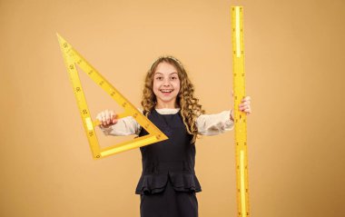 Çocuk okulu üniforması cetveli tutar. Geometri dersi. Eğitim ve okul konsepti. Zekice ve zekice bir fikir. Boyut ve boyut. Büyük cetveli olan tatlı bir öğrenci. Okul öğrencisi geometri okuyor.
