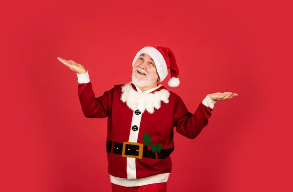 Őszintén gratulálok. Szakállas télapó sapkában, piros háttérben. Karácsonyi ajándékok és ajándékok vásárlása. téli ünnepi öröm. Vicces végzős Télapó jelmezben. Boldog új 2021-es évet. Boldog karácsonyt! — Stock Fotó
