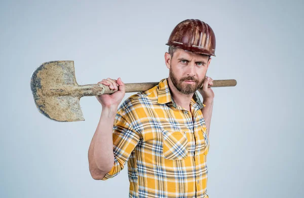 Bell'uomo esperto in costruzione casco di sicurezza e camicia a scacchi in cantiere con pala, occupazione — Foto Stock