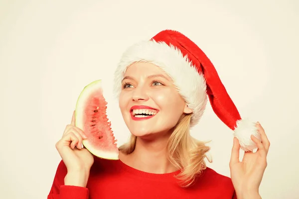 热带圣诞的概念。异国情调的寒假和假期圣诞女孩吃西瓜。女人的桑塔帽子拿着薄片西瓜.异国情调的圣诞庆典圣诞避暑胜地 — 图库照片