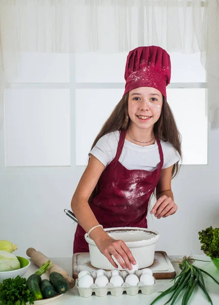 Plus que de la nourriture. bonne enfance. enfant heureux porter uniforme de cuisinier. chef fille en chapeau et tablier. cuisine pour enfants dans la cuisine. choisir une carrière. petite aide à la cuisson. cuisine et gastronomie — Photo