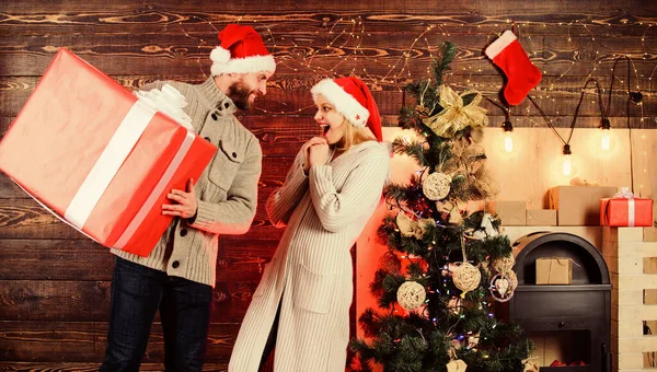 Feliz pareja amorosa. Año Nuevo. Entrega de regalos de Santa. Hora del saludo. Enorme sorpresa. fiesta de navidad familiar. ventas de temporada de invierno. la mujer y el hombre aman las navidades. pareja enamorada de santa hat. Regalos de vacaciones — Foto de Stock