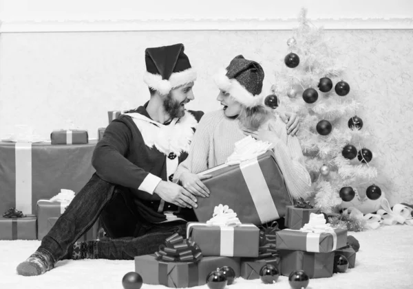 Älskade par packa upp gåva julgran bakgrund. Par i kärlek glad njuta av julhelgen firande. Maken förberedde julöverraskning. Öppnar julklapp. Vilken överraskning. — Stockfoto