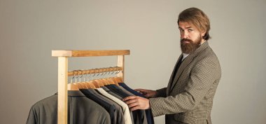 Kendine güvenen terzi erkek ceketi tasarlıyor. Mezura takan yakışıklı bir sartor. Erkek güzellik ve moda. Sakallı adam, terzi kıyafetleri. Resmi ve ofis kıyafetleri. İş adamı. İş tutkusu