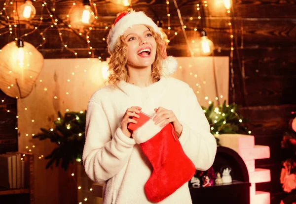 クリスマスプレゼント。新年明けましておめでとう。サンタクラスからの贈り物。赤いサンタの帽子の女の子。冬休みの飾り。陽気な女だな。クリスマスの準備だ。新年のプレゼント。プレゼント付きのクリスマスストッキング — ストック写真