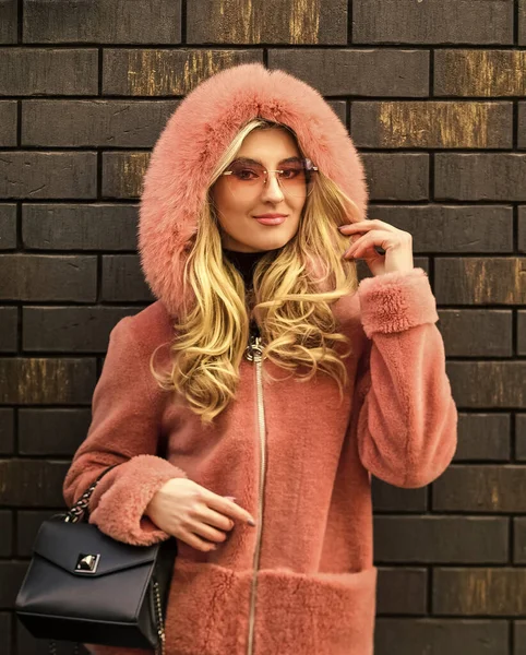 Belle femme élégante marchant en manteau rose. tenant le sac dans les mains. style de rue. tendance printemps été. Femme à la mode en manteau de fourrure rose. saison froide. Look automne ou hiver — Photo