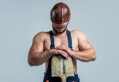 Geleceğini kendin kur. Başlıklı inşaat işçisi. İşçi bayramı. Atletik adam güvenlik kaskı takıyor. Erkek mühendis kürekle çalışıyor. Mayolu seksi bir müteahhit. İnşaat alanındaki kaslı adam.