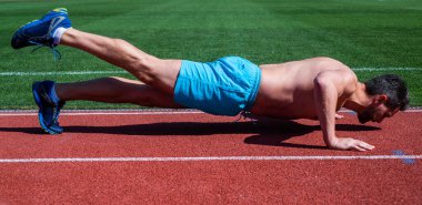 Sporcu erkek, açık hava stadyumunda şınav çekiyor, spor yapıyor.