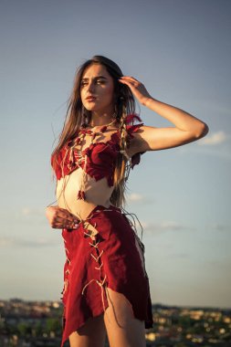 Ezoterizm ve okültizm. Vahşi ve tehlikeli. Ruhsal gelişim. Deri elbiseli bir kadın gökyüzü arka planı. Etnik kabile kavramı. Seksi kızmış. Kabile kıyafetleri. Kabile kültürü. Köklerine geri dön.