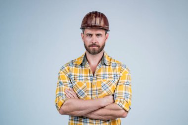 İnşaat kaskı ve inşaat alanında kareli gömlek giyen yakışıklı mühendis.