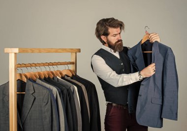 Moda tasarımcısı. Kendine güvenen terzi erkek ceketi tasarlıyor. Mezura takan yakışıklı bir sartor. Erkek güzellik ve moda. Sakallı adam, terzi kıyafetleri. Resmi ve ofis kıyafetleri. İş adamı