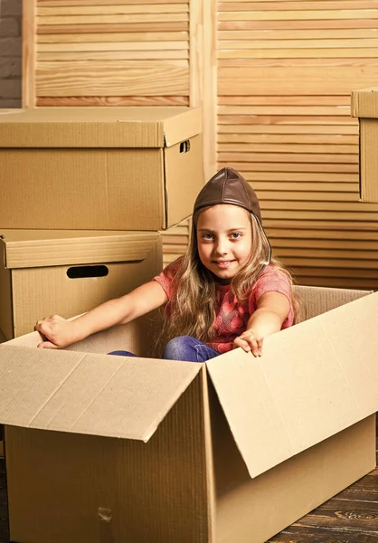 变化就在空气中。纸板箱-搬到新房子。快乐的小女孩带着玩具。修理房间。新公寓。购买新住所。快乐的孩子纸盒 — 图库照片