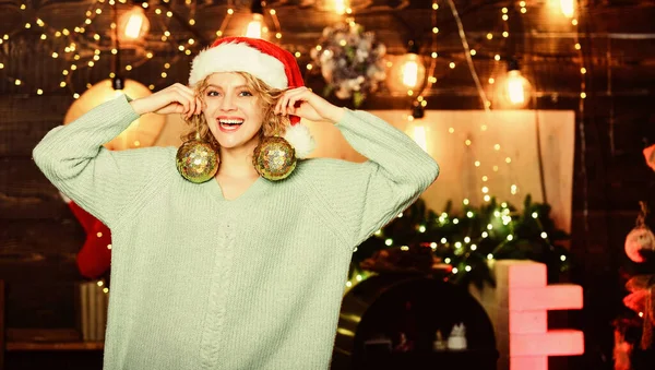 Flicka tomte hatt hålla gyllene bollar dekorationer för julgran. Inspektera din jul dekorationer och ersätta allt som är utslitet. Förbered dekorationer i förväg. Dekorativa tillbehör butik — Stockfoto