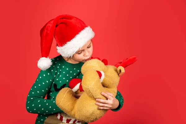 Aiutante di Babbo Natale. Vacanze invernali. Sconto stagionale. La bambina porta un peluche. Vendita di Natale. Regalo di renne per bambini. Spirito natalizio. Vacanze di Natale attributi culturali. Renna e Babbo Natale — Foto Stock