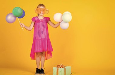 Güzel bir tatil partisi. Çocuk eğleniyor. Uluslararası Çocuk Günü. Mutlu çocukluk. Balonlu küçük çocuk. Entertainment doğum günü konsepti. Çocuk balonlarla ve hediye kutusuyla parti veriyor.