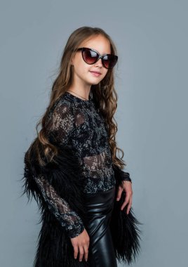 Kıvırcık saçlı, gözlüklü neşeli çocuk.