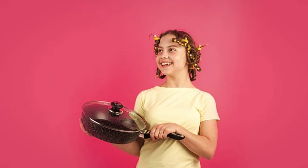 Pequena dona de casa engraçada com pan. bonito engraçado menina vestindo o curler e com a panela. menina pequena dona de casa cozinhar na cozinha. Retrato de menina bonito com panela. Quem se importa com a dieta — Fotografia de Stock