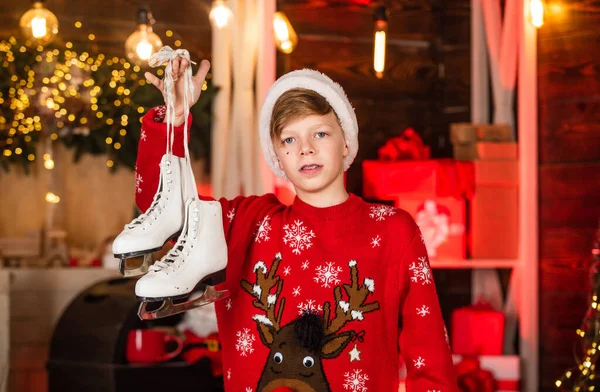 Noel Baba şapkalı çocuk paten kaymaya gidiyor. Patenlerle iyi eğlenceler. Mutlu noeller. Güzel Xmas hediyesi. Kış tatili aktivitesi. Mutlu genç yeni yıl partisini kutluyor. Kırmızı rengeyiği süveterli küçük çocuk. — Stok fotoğraf