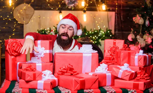 Beste prijzen voor de winter geschenken. Man Kerstman hoed gluurt uit stapel geschenken. Kerstman met geschenken. Seizoensgebonden aanbod. Kerstverkoop. Vakantie gevuld met plezier. Baard Kerstman en vele vakantiepakketten — Stockfoto