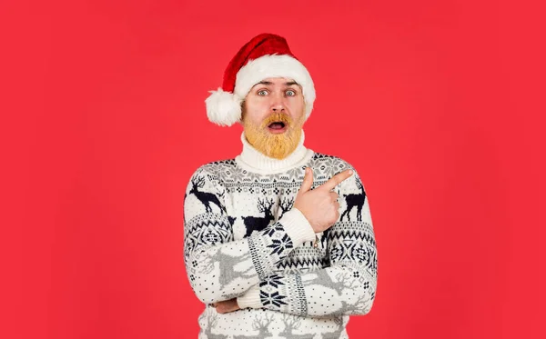 New year party is here. christmas shopping time. mature male knitted xmas sweater. brutal man hate winter holidays. surprised man santa hat. bearded hipster dyed hair red background — Stock Photo, Image