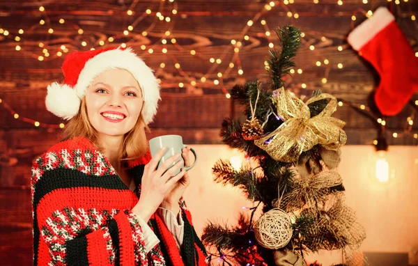 Bevi un caffè. Casa accogliente. Una donna festeggia il Natale a casa. Concetto vigilia di Natale. Ricetta cioccolata calda. Ragazza in cappello di Babbo Natale pronto a incontrare il nuovo anno. Donna con tazza che celebra le vacanze invernali Natale — Foto Stock