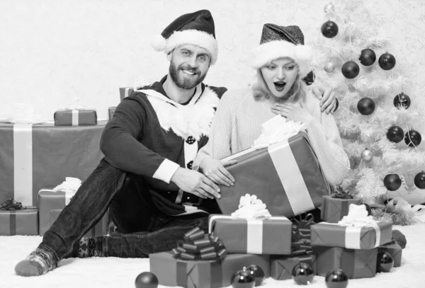 Man bereidde kerstverrassing voor. Een kerstcadeautje openen. Liefdevol koppel uitpakken cadeau kerstboom achtergrond. Wat een verrassing. Verliefd paar genieten van kerstvakantie viering — Stockfoto